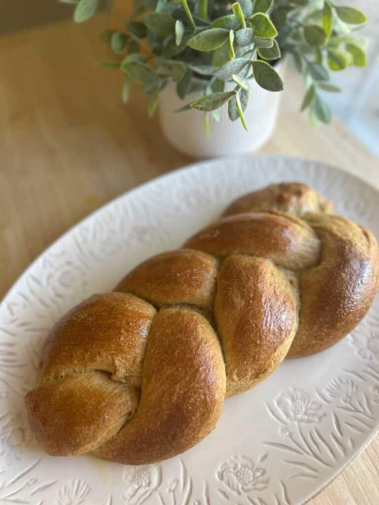 braided brioche bread on a pretty white plate