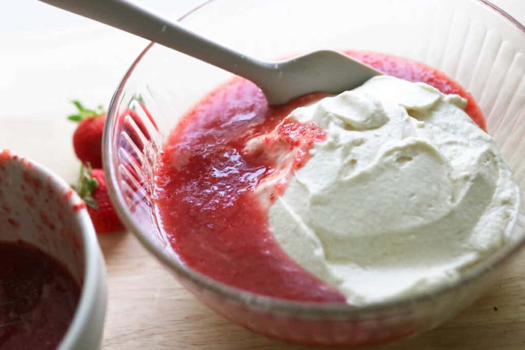 folding strawberry puree into whipped cream