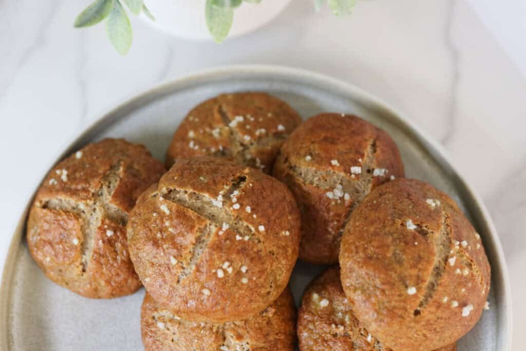 pretzel buns on a plate with flaky salt