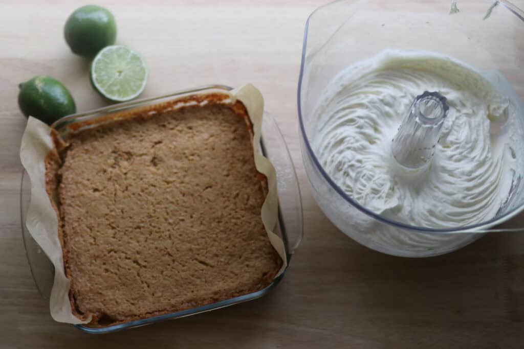 Key lime pie bars and homemade whipped cream with limes