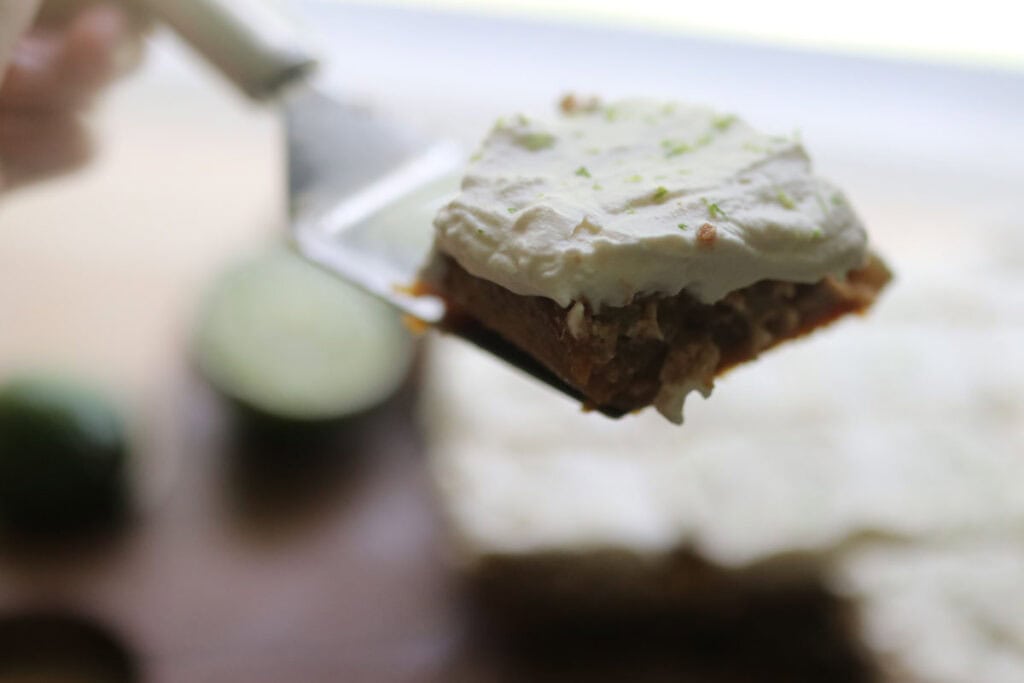 a freshly milled key lime pie bar with lime zest on a serving spatula