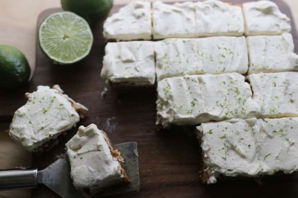freshly milled key lime pie bars on a cutting board that have been cut.