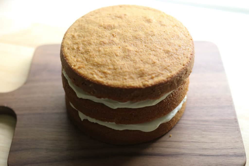 3 layers of yellow cake on a cutting board