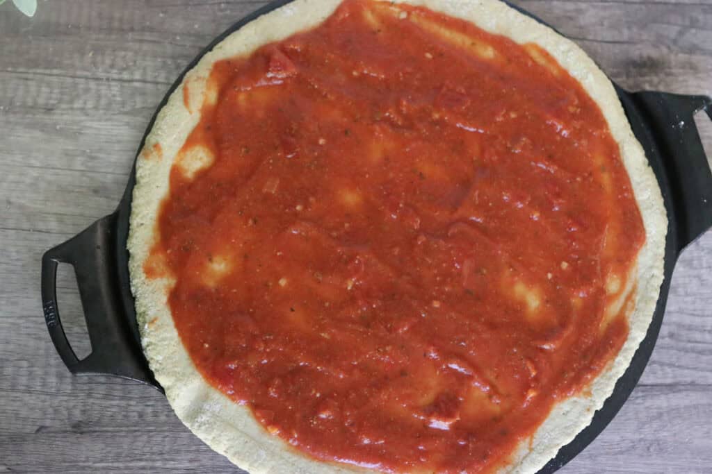 pizza crust with tomato sauce on it