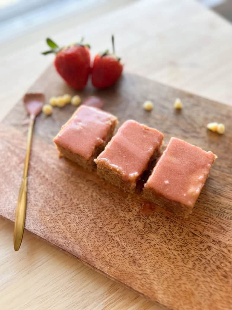 three strawberry brownies with berries and spoon