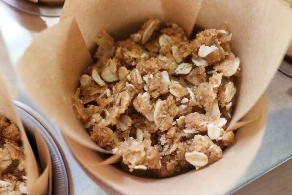 a fresh milled sourdough banana crumble muffin in a parchment liner