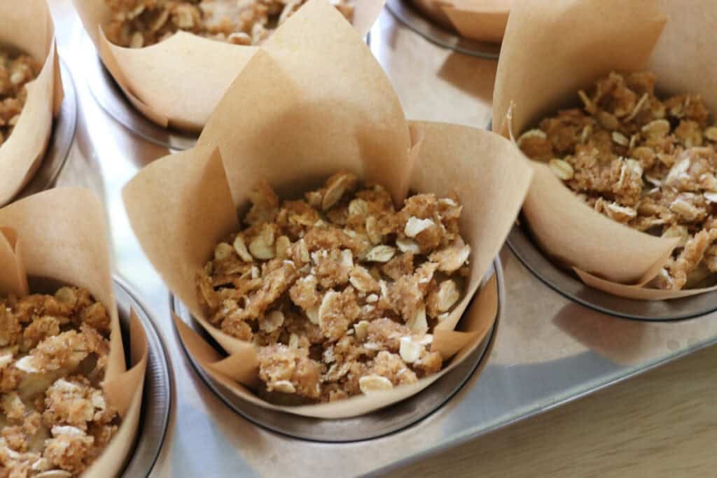 fresh milled sourdough banana crumble muffins in a stainless steel muffin pan
