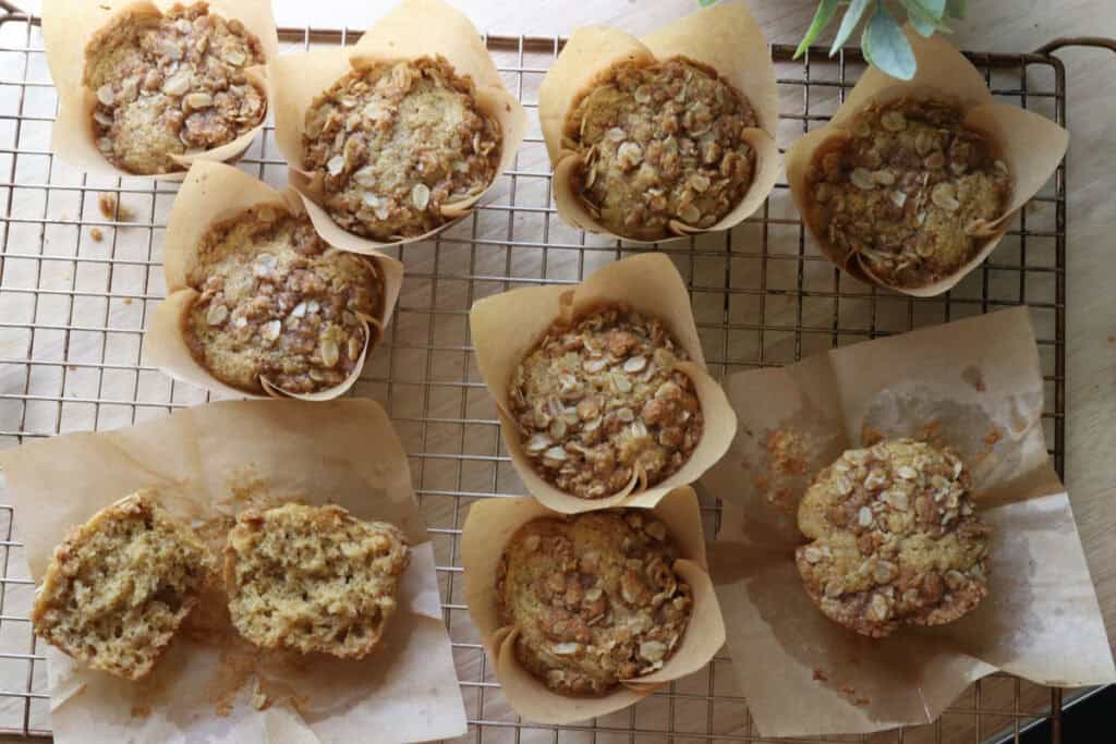 fresh milled sourdough banana crumble muffins in parchment liners on a baking rack