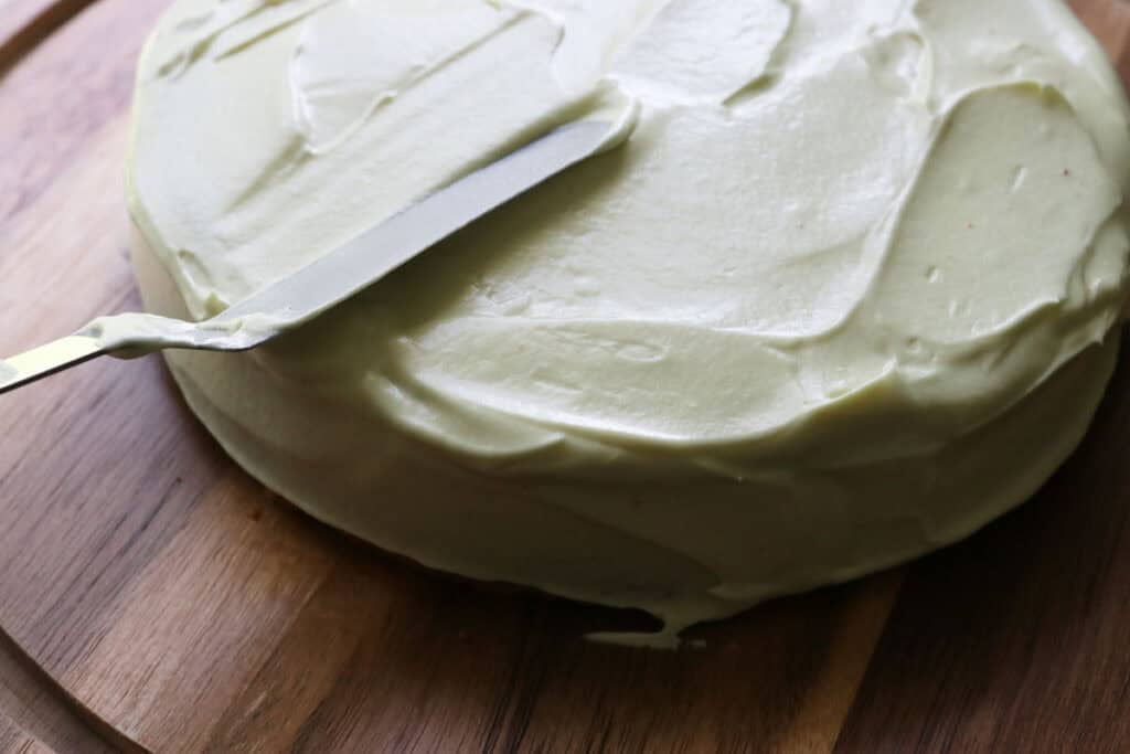icing the freshly milled lemon chantilly cake with an offset spatula