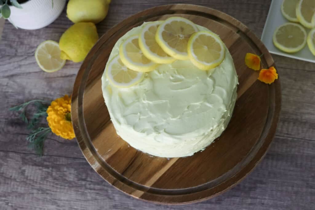 freshly milled lemon chantilly cake on a wooden cake stand