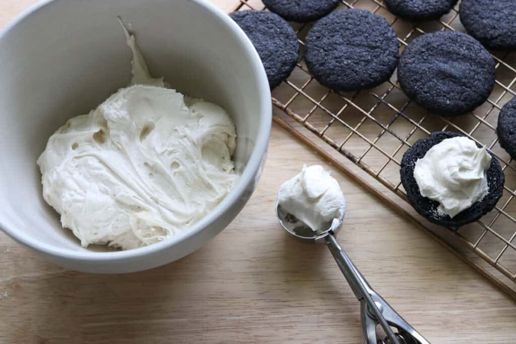 icing in a cookie scoop to put on fresh milled homemade oreo cookies