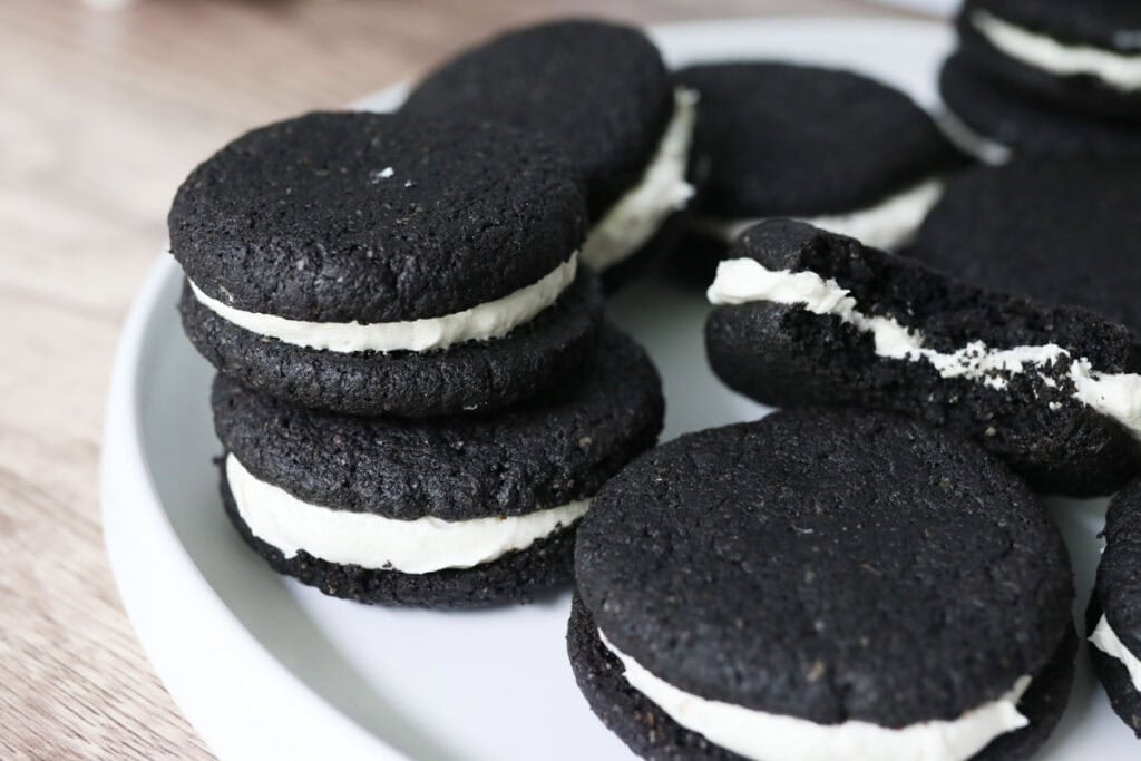 delicious homemade fresh milled homemade oreos with icing in the middle on a white plate 