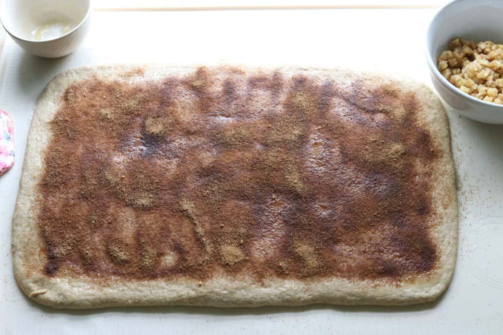 cinnamon and sugar sprinkled on fresh milled twisted apple cinnamon dough