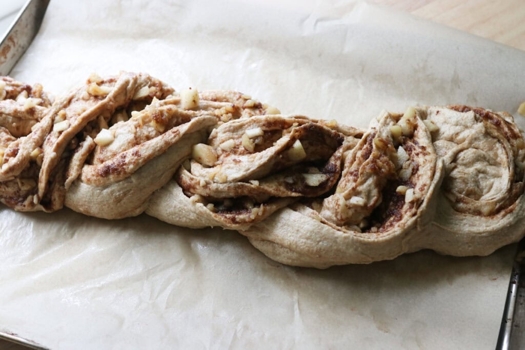 fresh milled twisted apple cinnamon loaf that has been twisted on parchment paper