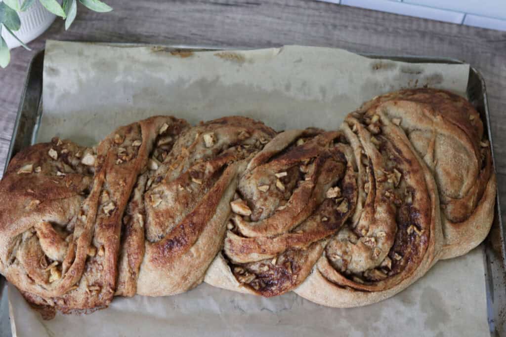 fresh milled twisted apple cinnamon loaf on a wooden counter that has been baked