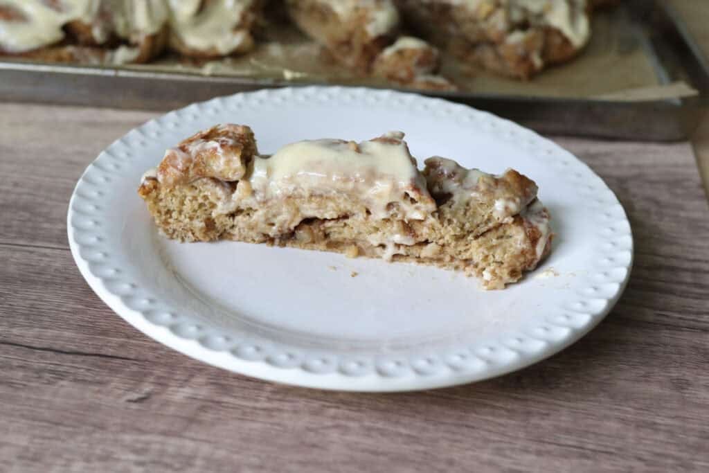 a slice of fresh milled twisted apple cinnamon loaf on a white plate