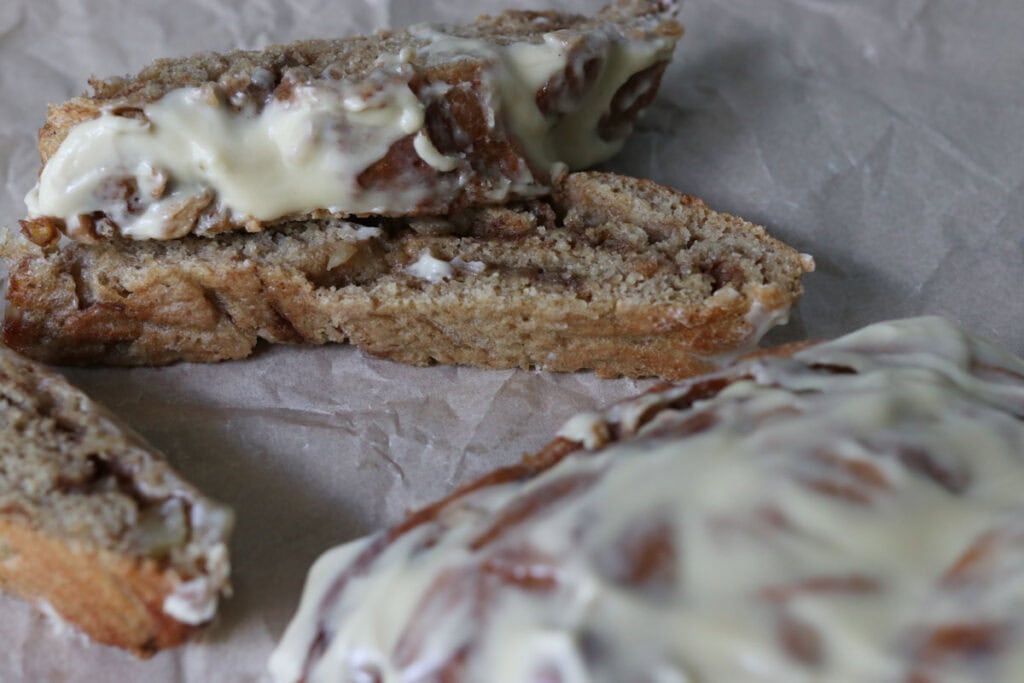 a slice of fresh milled twisted apple cinnamon loaf stacked on top of another slice on parchment paper