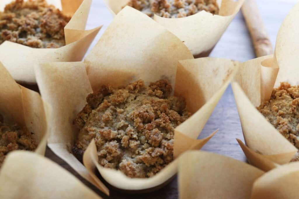 a freshly milled apple cinnamon muffin with streusel topping wrapped in parchment paper