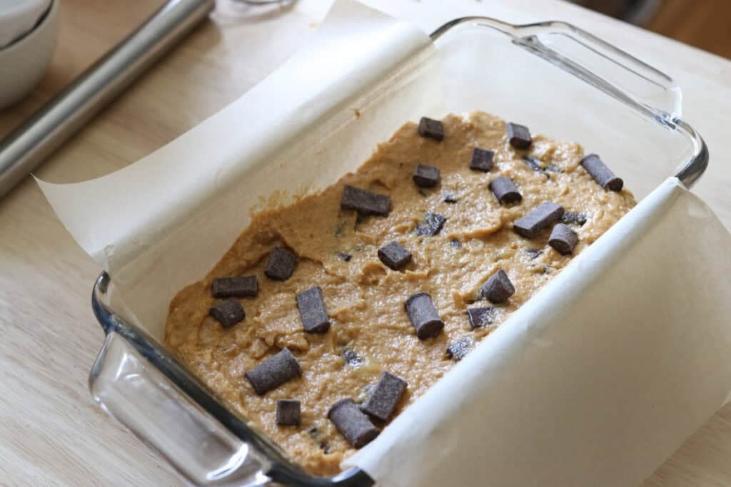 the batter for fresh milled pumpkin chocolate chip banana bread in a glass pan