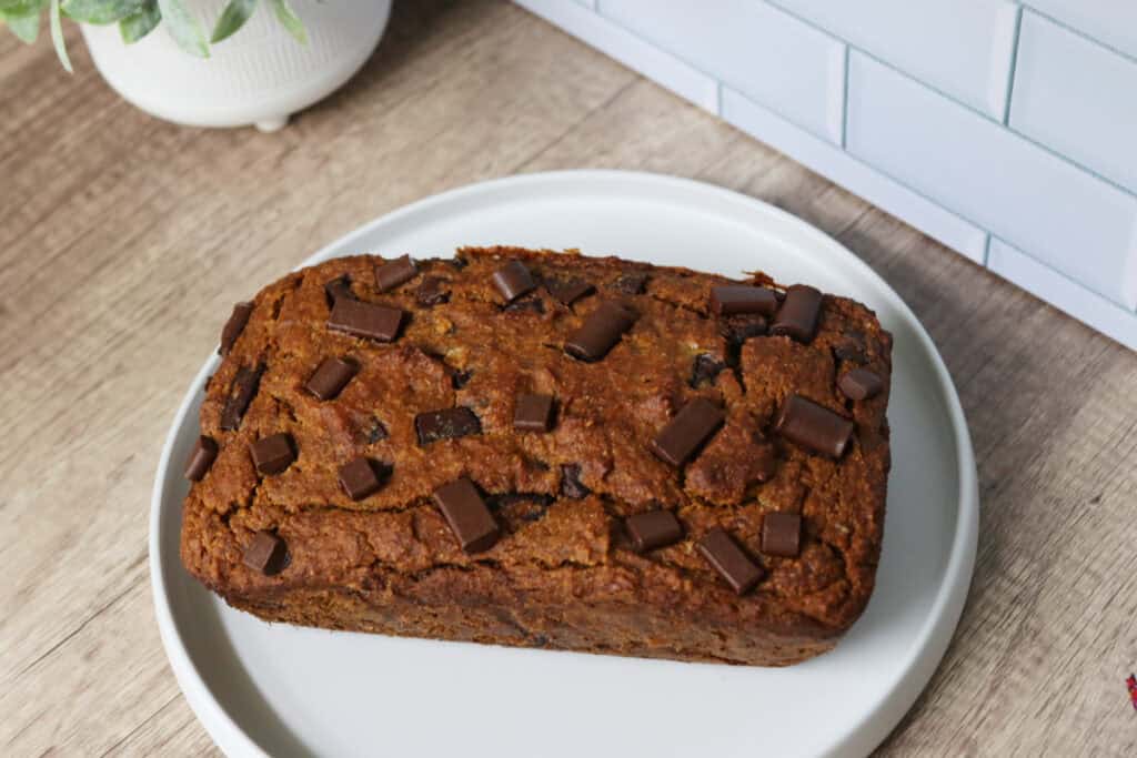 a loaf fresh milled pumpkin chocolate chip banana bread on a white plate