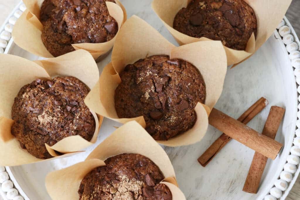 freshly milled chocolate chip cappuccino muffins with cinnamon sticks on a white tray