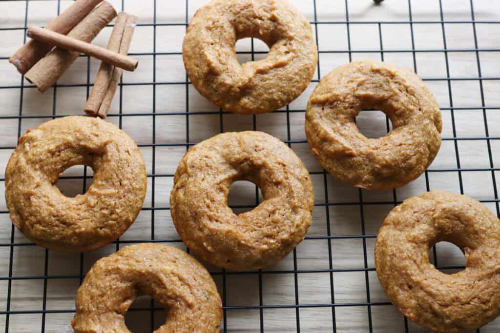 fresh milled cinnamon sugar pumpkin cake donuts cooling on a baking rack