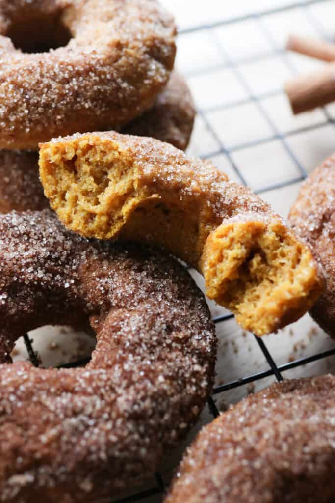a fresh milled cinnamon sugar pumpkin cake donut cut in half