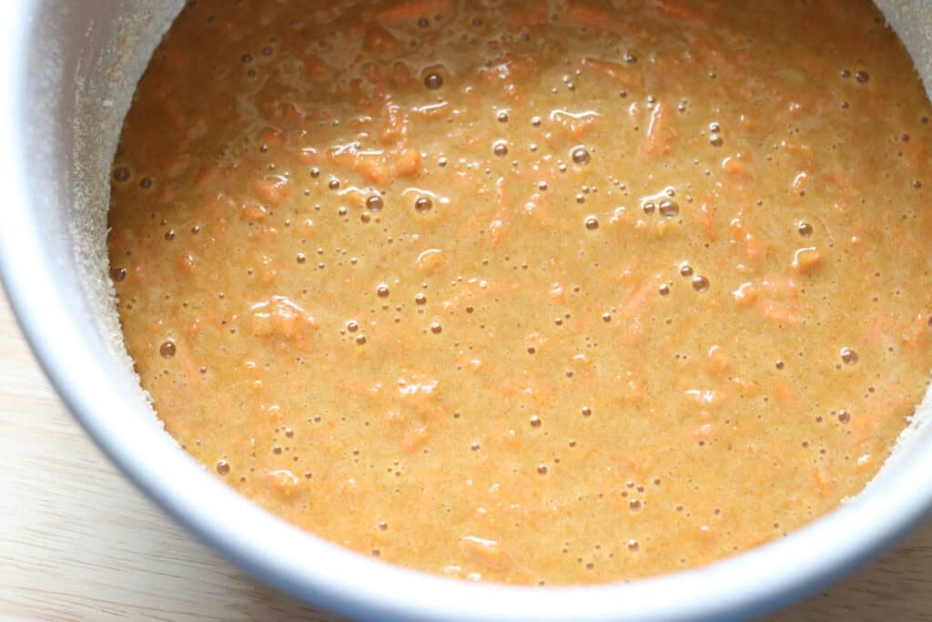 cake batter in a round cake pan to make freshly milled carrot cake with cream cheese icing