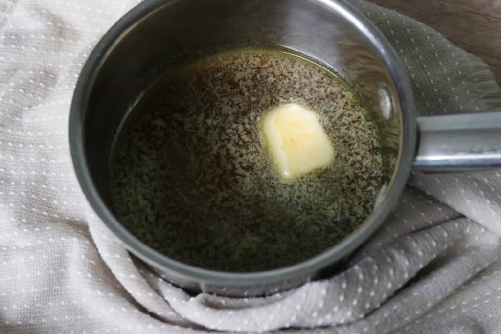 melted butter and maple syrup in a bowl to make the glaze for fresh milled maple brown sugar cookies