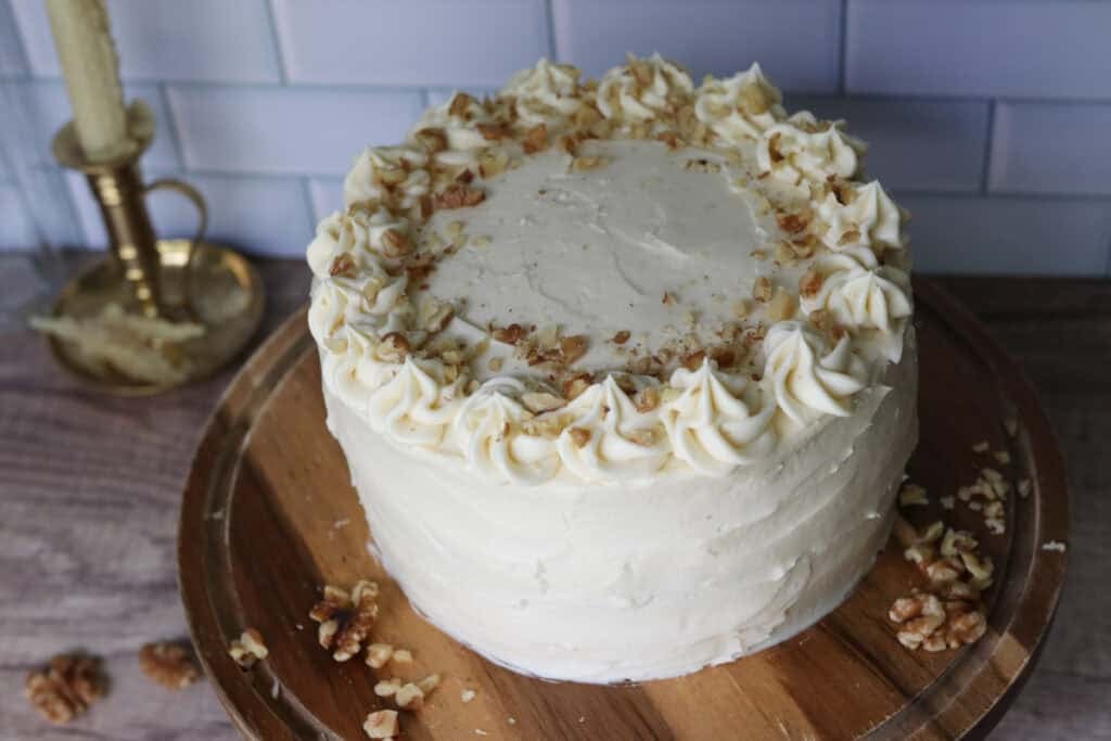 freshly milled carrot cake with cream cheese icing on a wooden cake stand