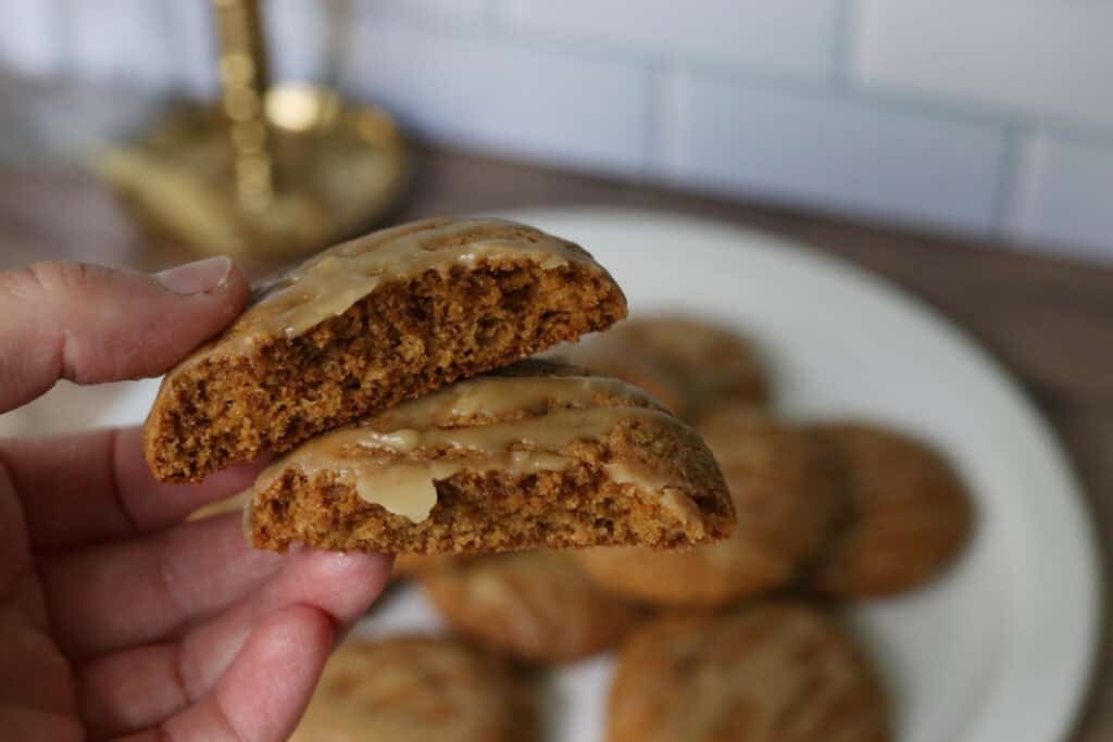 two halves of a fresh milled maple brown sugar cookie being held by someone