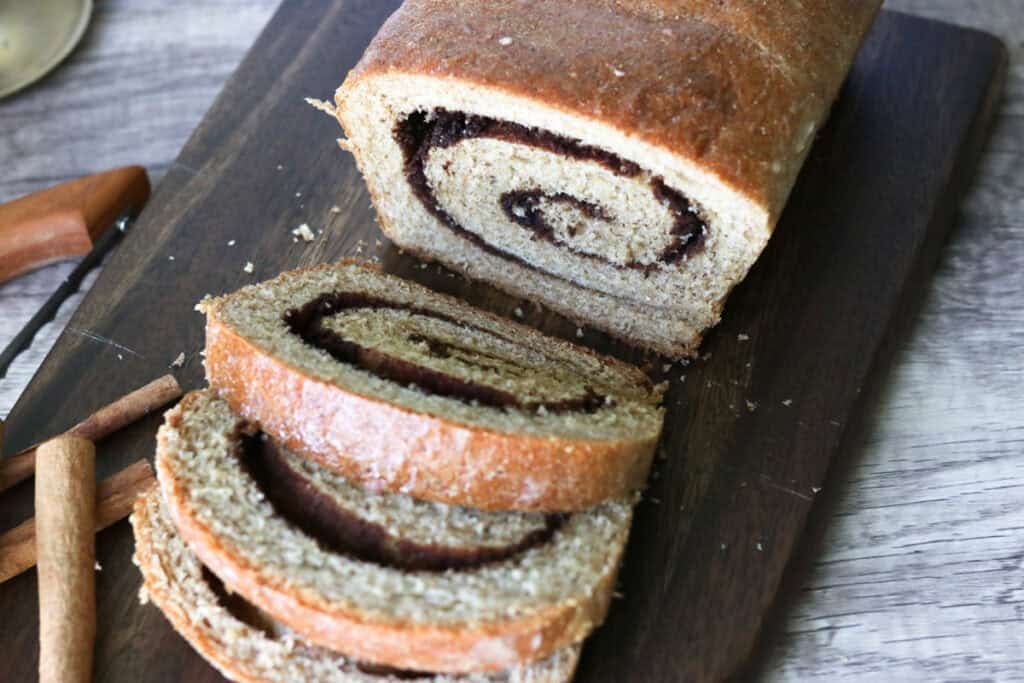 fresh milled bread with cinnamon swirls in the middle on a cutting board