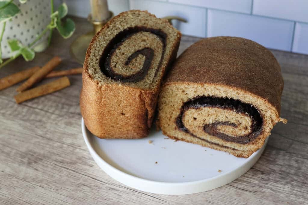 two halves of the most delicious fresh milled cinnamon swirl bread on a white plate
