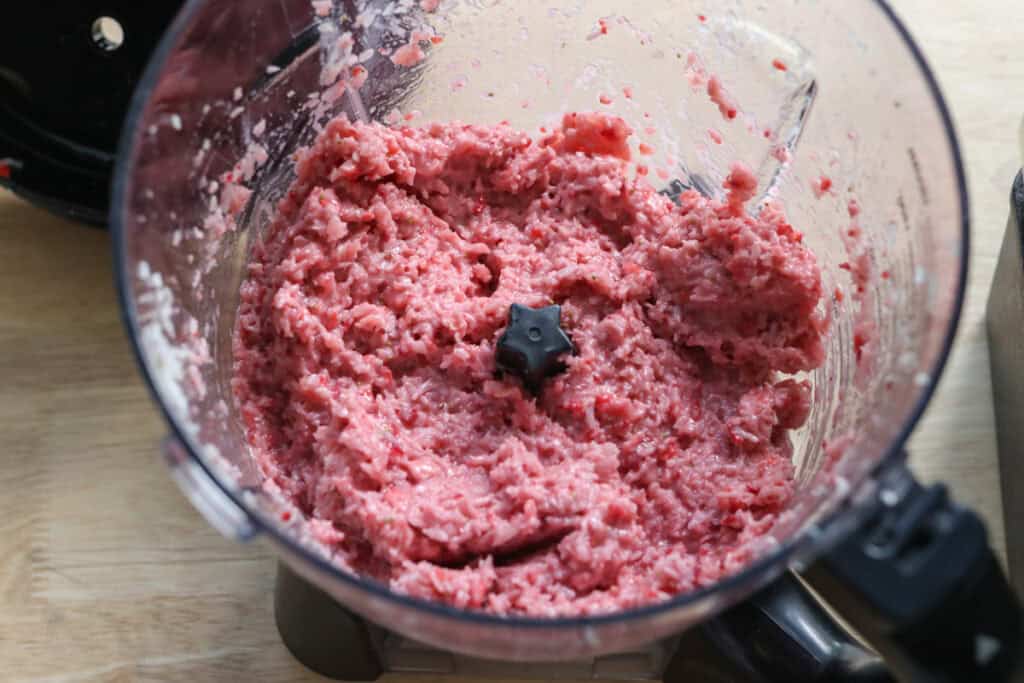 filling ingredients in a blender to make chocolate covered strawberries & cream coconut bars