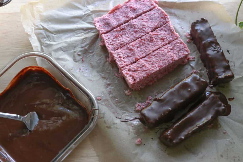 chocolate covered strawberries & cream coconut bars and melted chocolate on a table