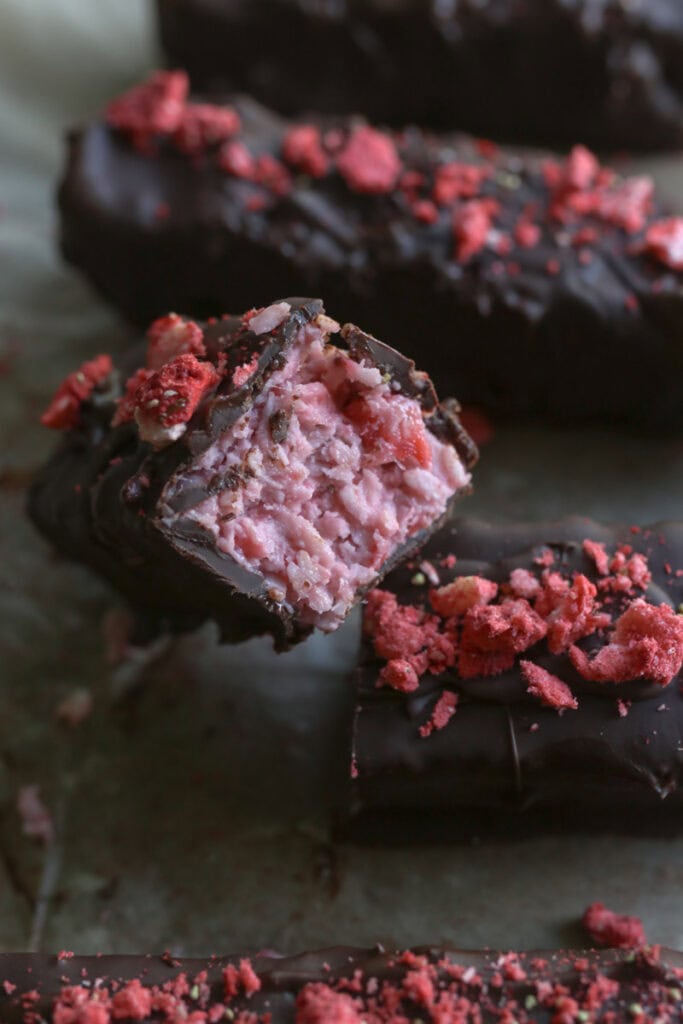 a chocolate covered strawberries & cream coconut bar cut in half