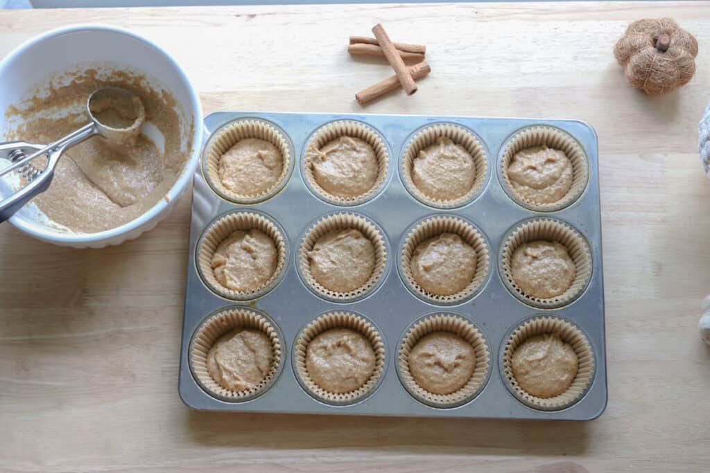 fresh milled apple cider cupcake batter in liners in a cupcake pan