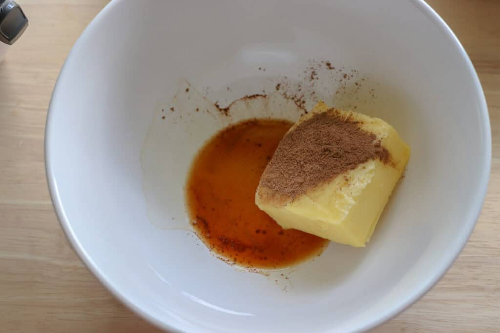 butter and spices in a white bowl to make buttercream to go on fresh milled apple cider cupcakes