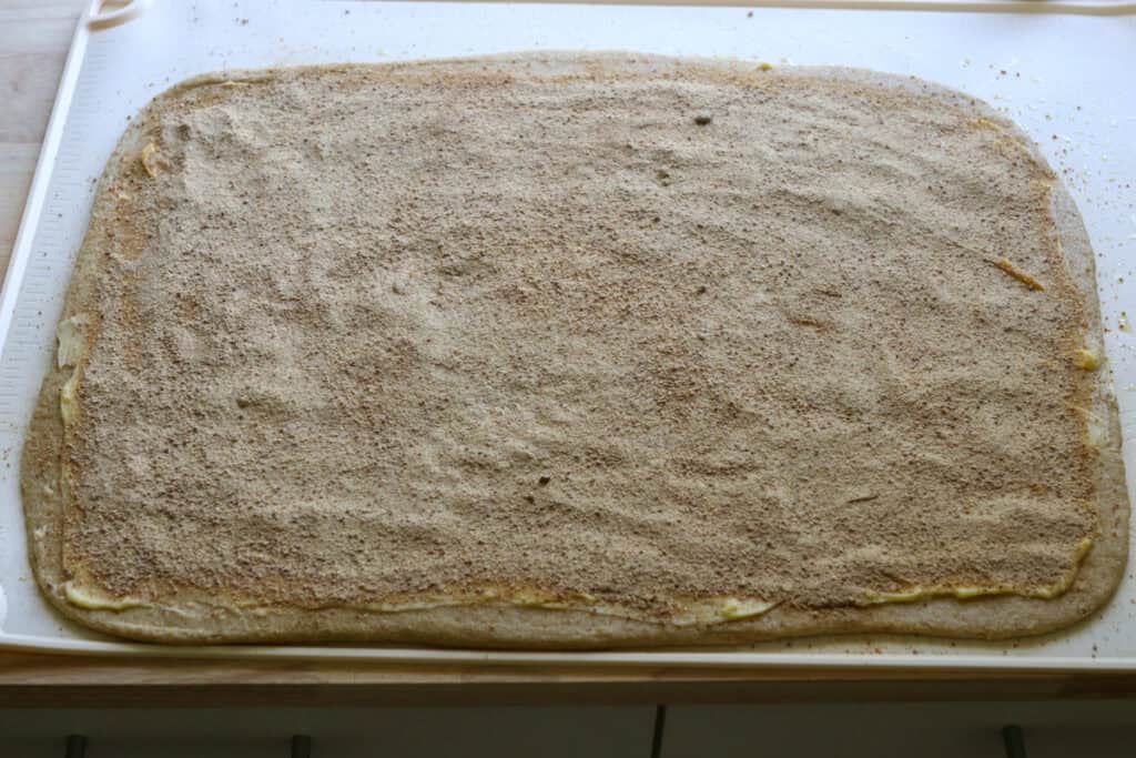 cinnamon and sugar sprinkled on top of  freshly milled apple cinnamon roll dough