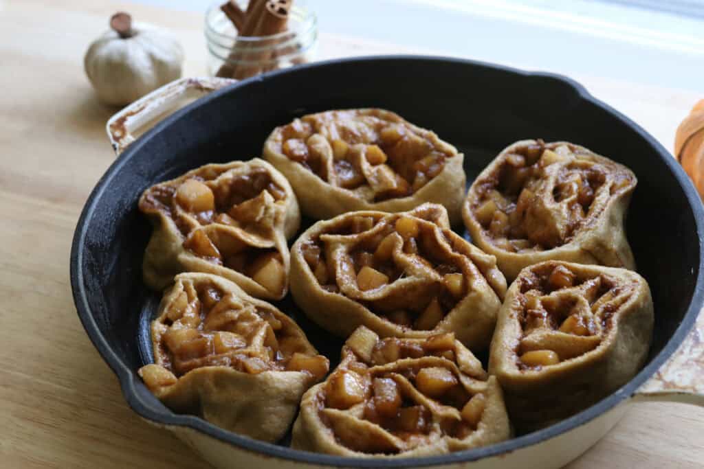  freshly milled apple cinnamon rolls in a skillet to rise