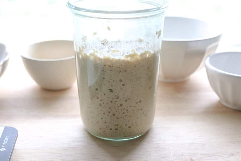 active sourdough starter in a glass jar to make Super Soft Freshly Milled Sourdough Sandwich Bread
