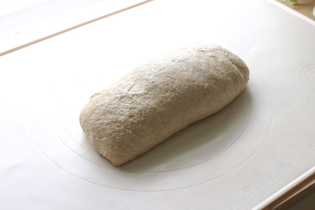 freshly milled sourdough that has been rolled into a log to make Super Soft Freshly Milled Sourdough Sandwich Bread