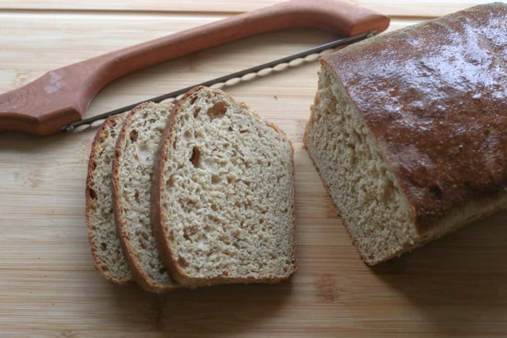 Super Soft Freshly Milled Sourdough Sandwich Bread that has been sliced with a wooden bread knife