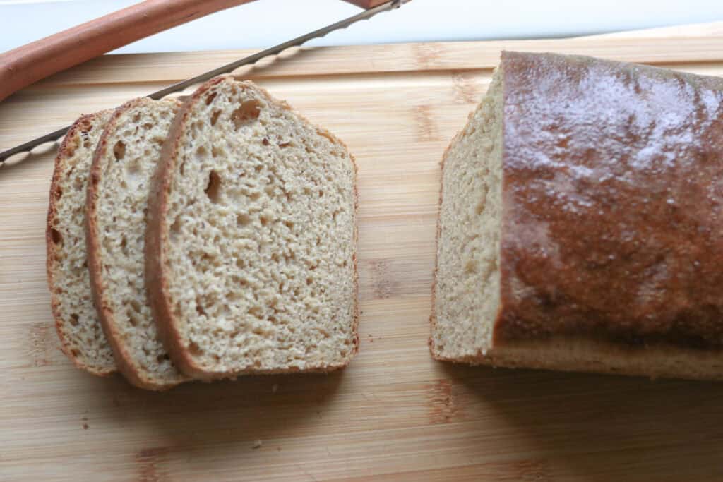 Super Soft Freshly Milled Sourdough Sandwich Bread with 3 slices cut on a wooden cutting board