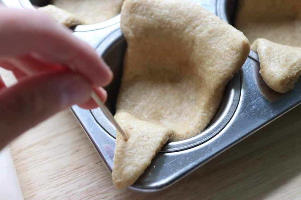 poking a freshly milled turkey dinner roll with a toothpick to make an eye