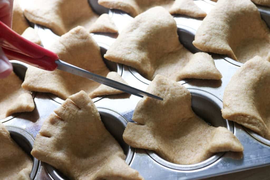 cutting freshly milled turkey dinner rolls with scissors to create feathers