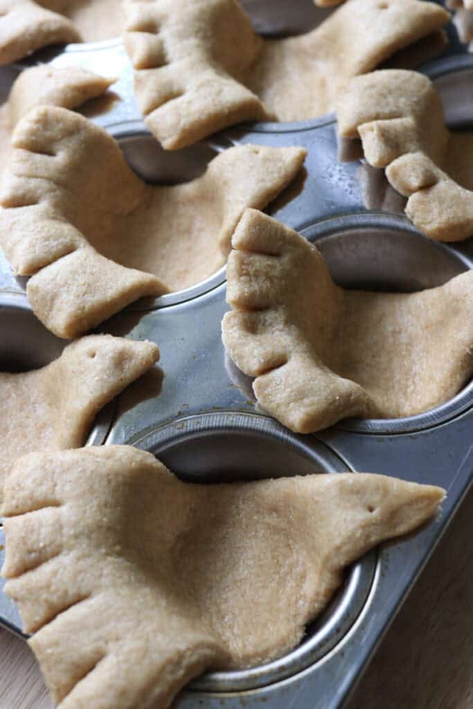freshly milled turkey shaped dinner rolls that have been cut to make feathers in a muffin pan