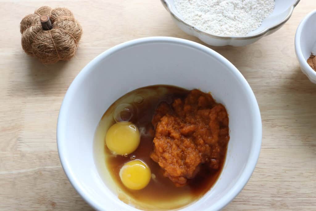 eggs, pumpkin puree, and maple syrup in a bowl to make baked pumpkin donut holes with fresh milled flour