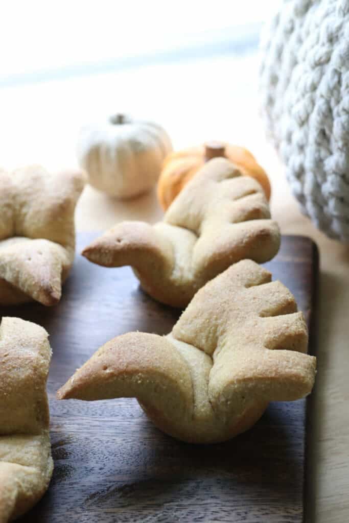 two freshly milled turkey shaped dinner rolls with feathers cut out on the back