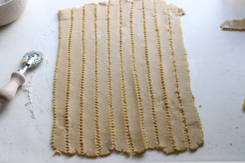 freshly milled apple pie dough cut into strips to make lattice for an apple pie